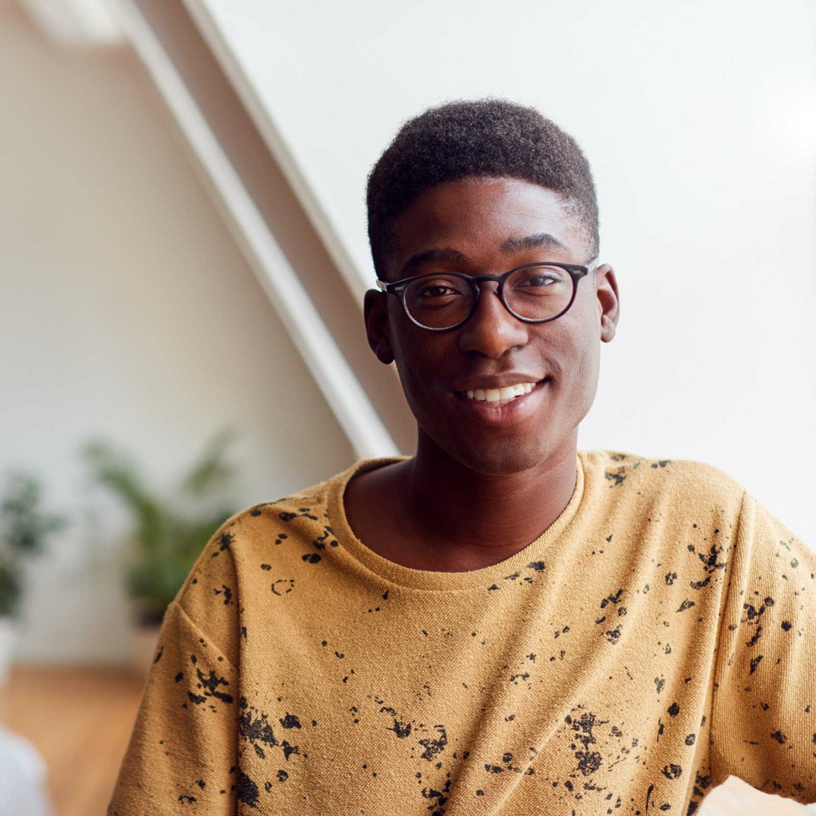 portrait-of-smiling-young-man-in-loft-apartment